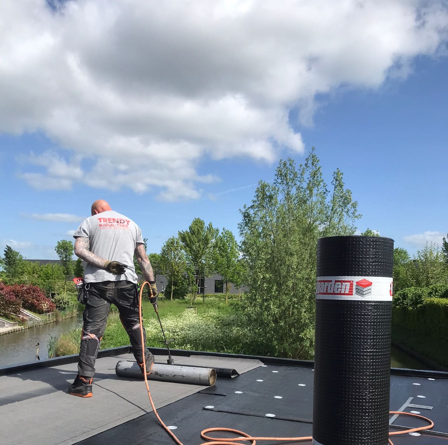 Dakdekker brandt bitumen op een plat dak